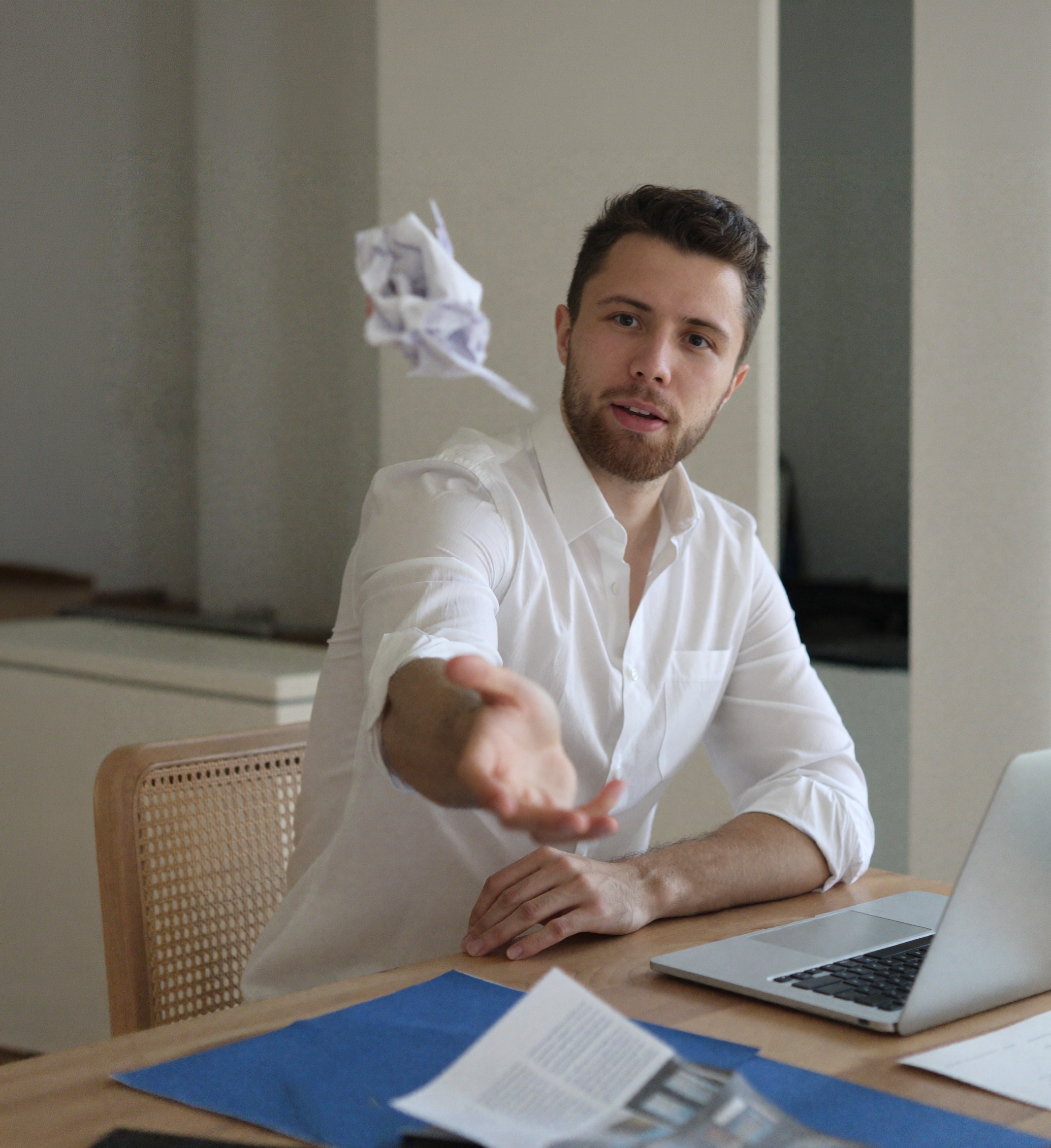 Julius at his desk, mid-throw of a balled-up sheet of paper.